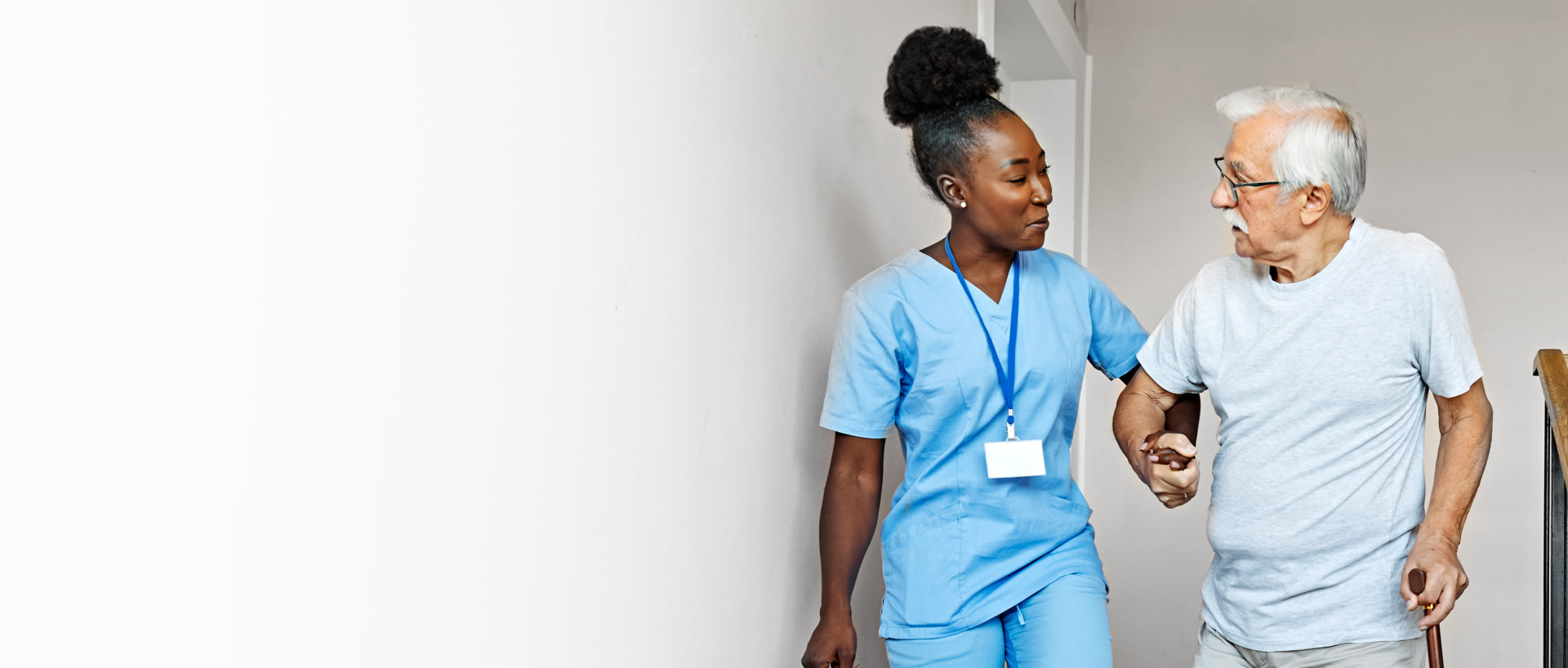 A caregiver assisting elderly man