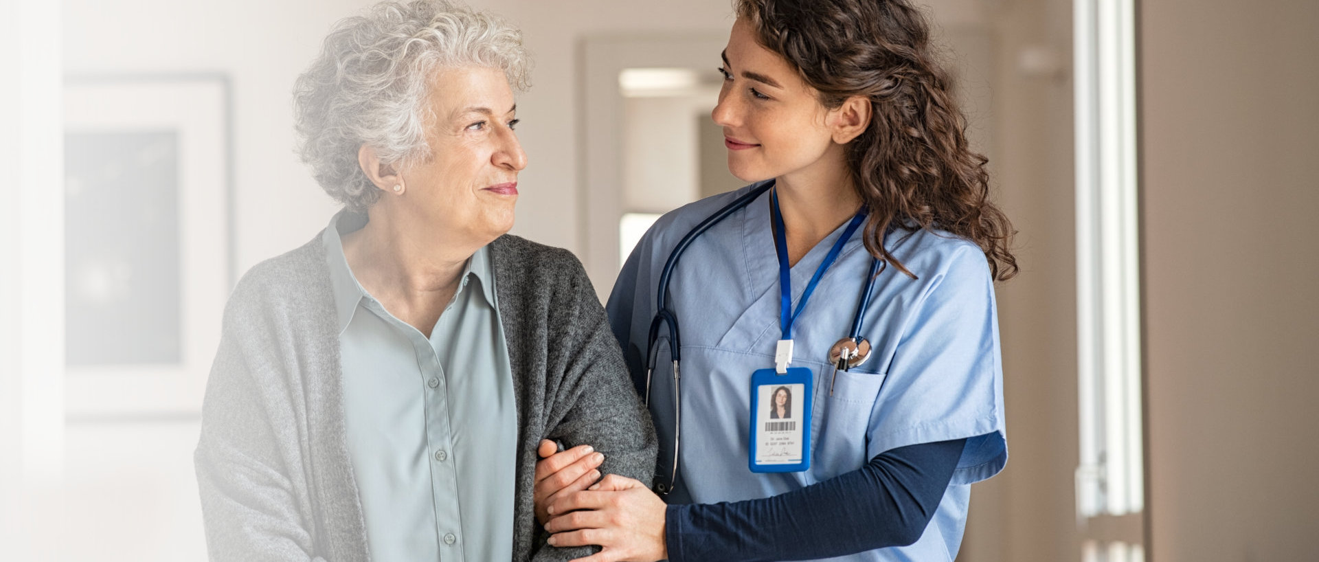 A caregiver and elderly smiling together