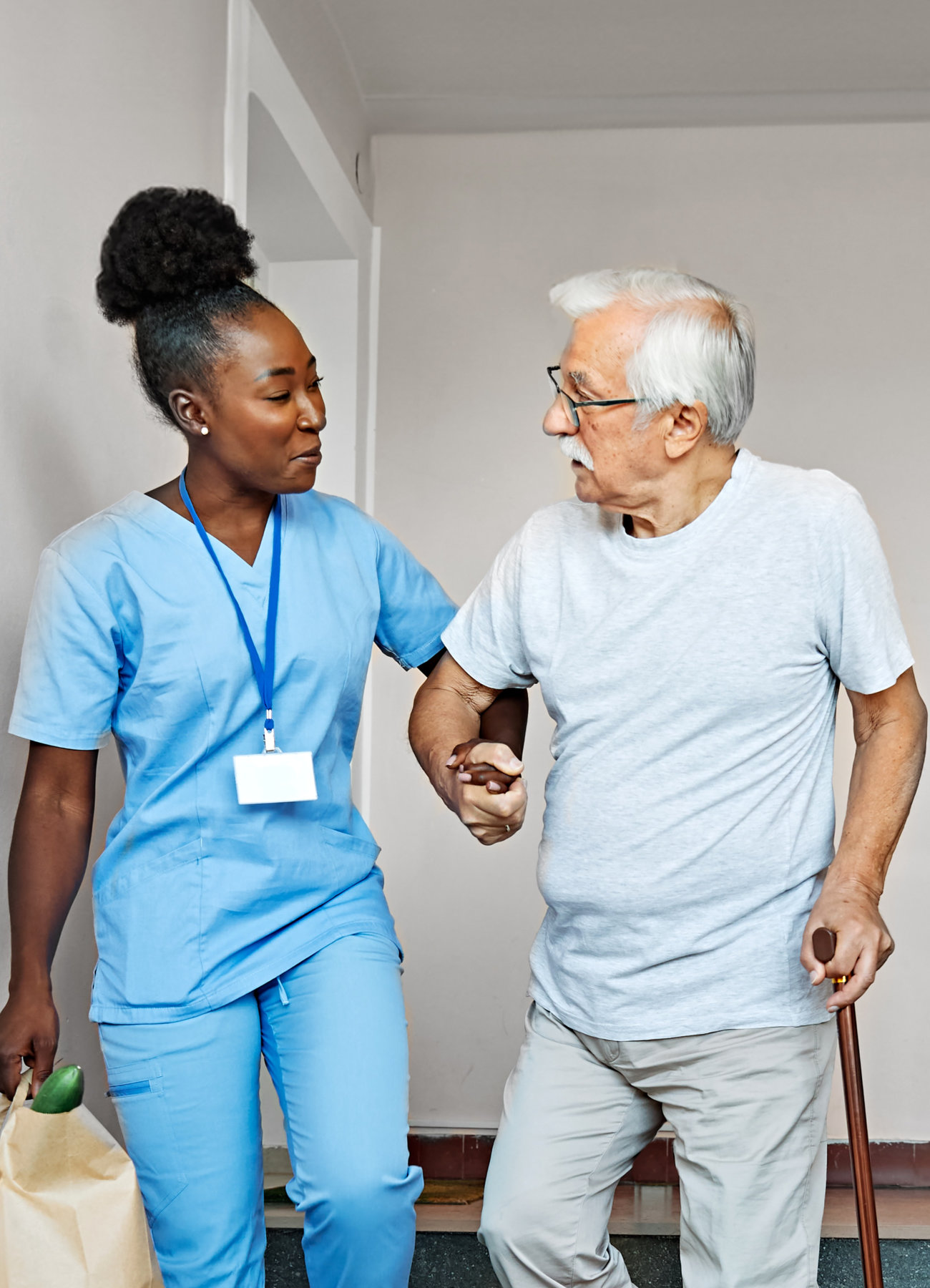 A caregiver assisting elderly man