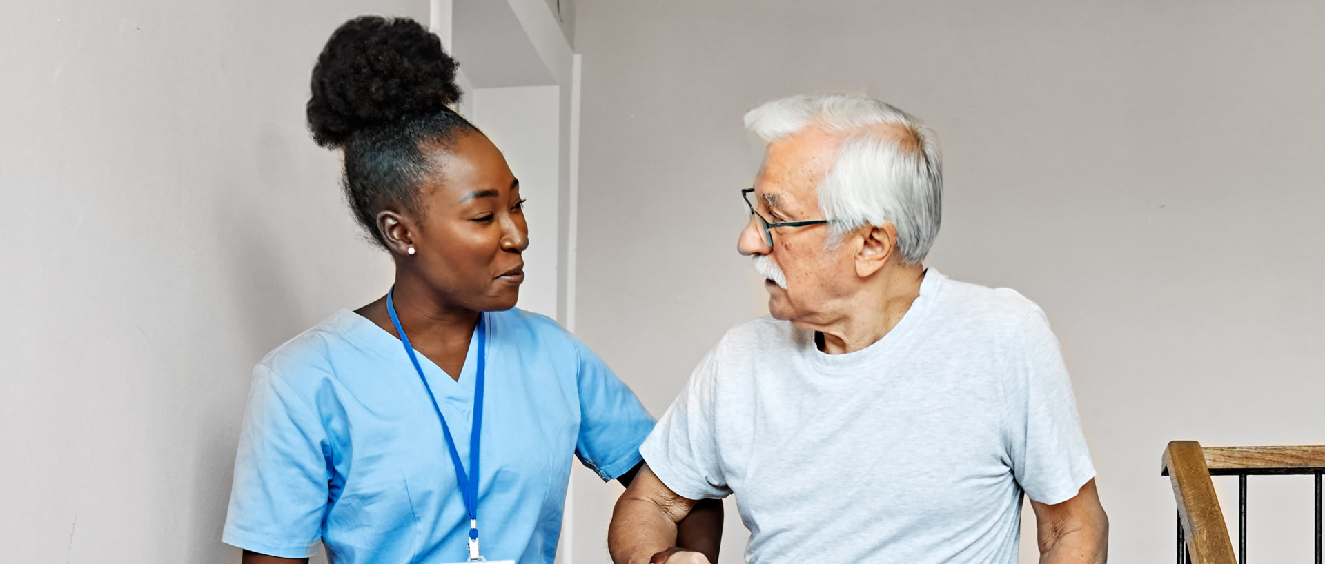 A caregiver assisting elderly man