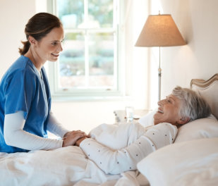 Shot of a young nurse chatting with a senior woman in bed